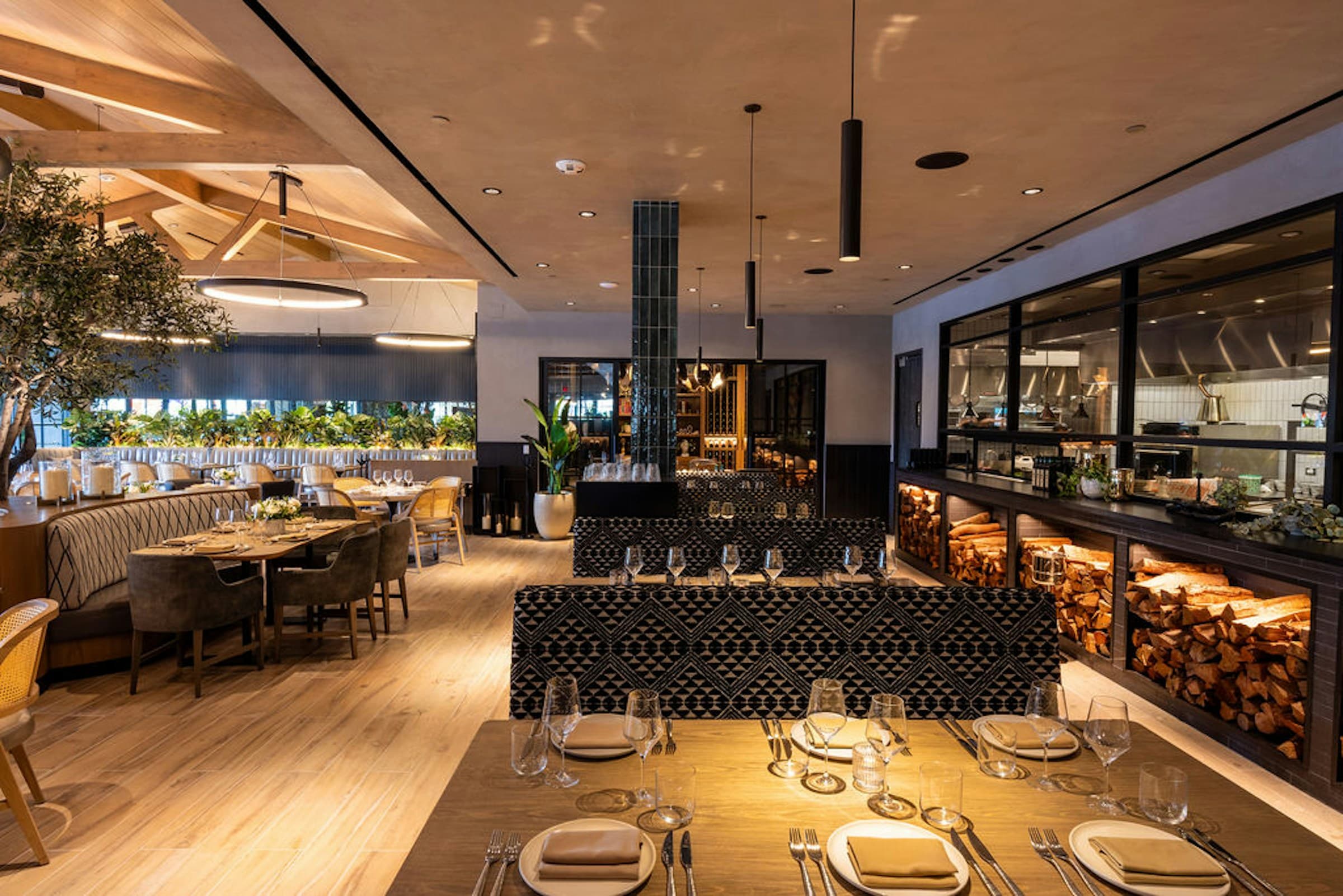 Tables facing the open wood-fire kitchen
